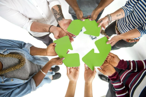 Diverse hands holding a recyling symbol